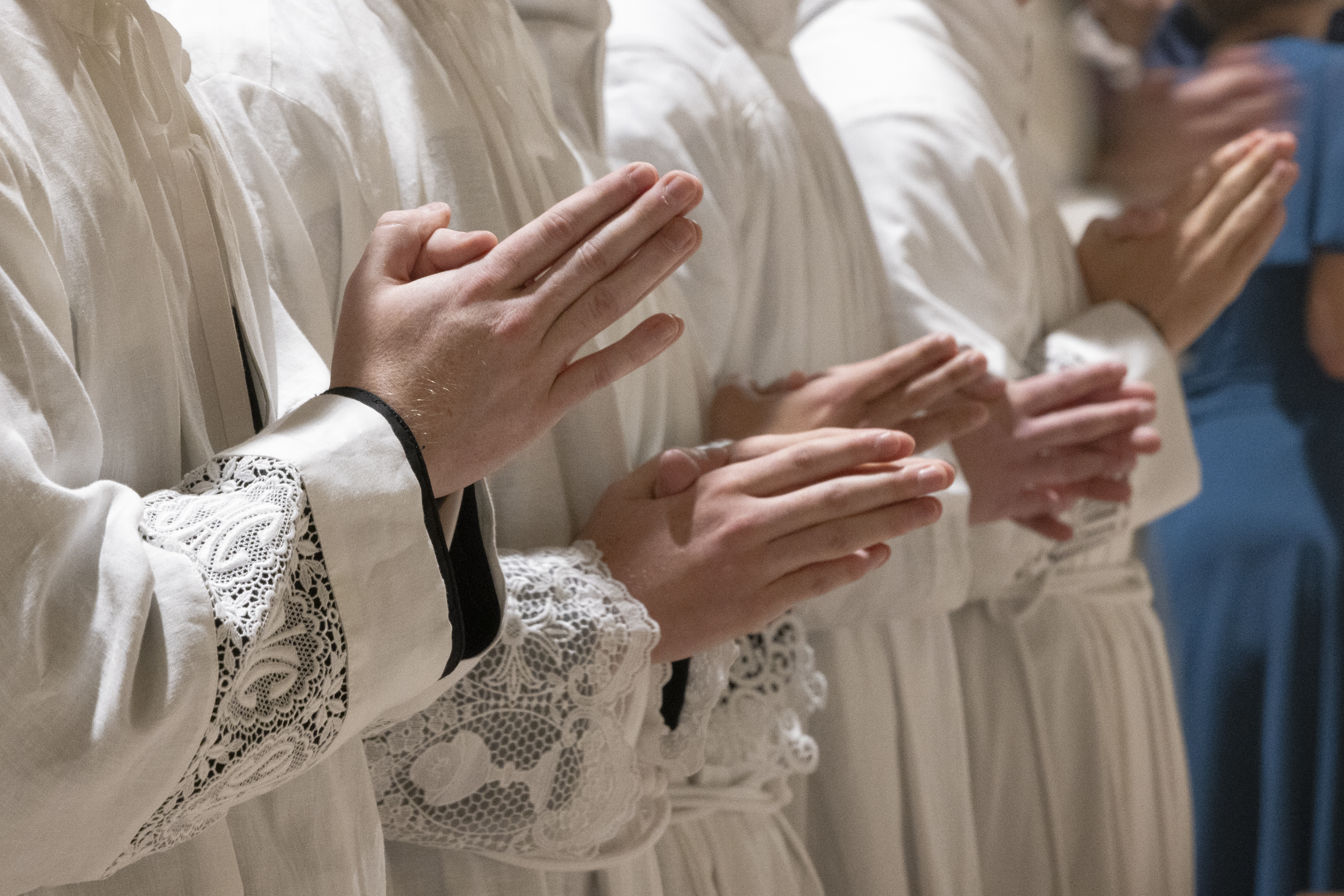Seminarians stood with their hands folded in prayer at their ordination Mass.