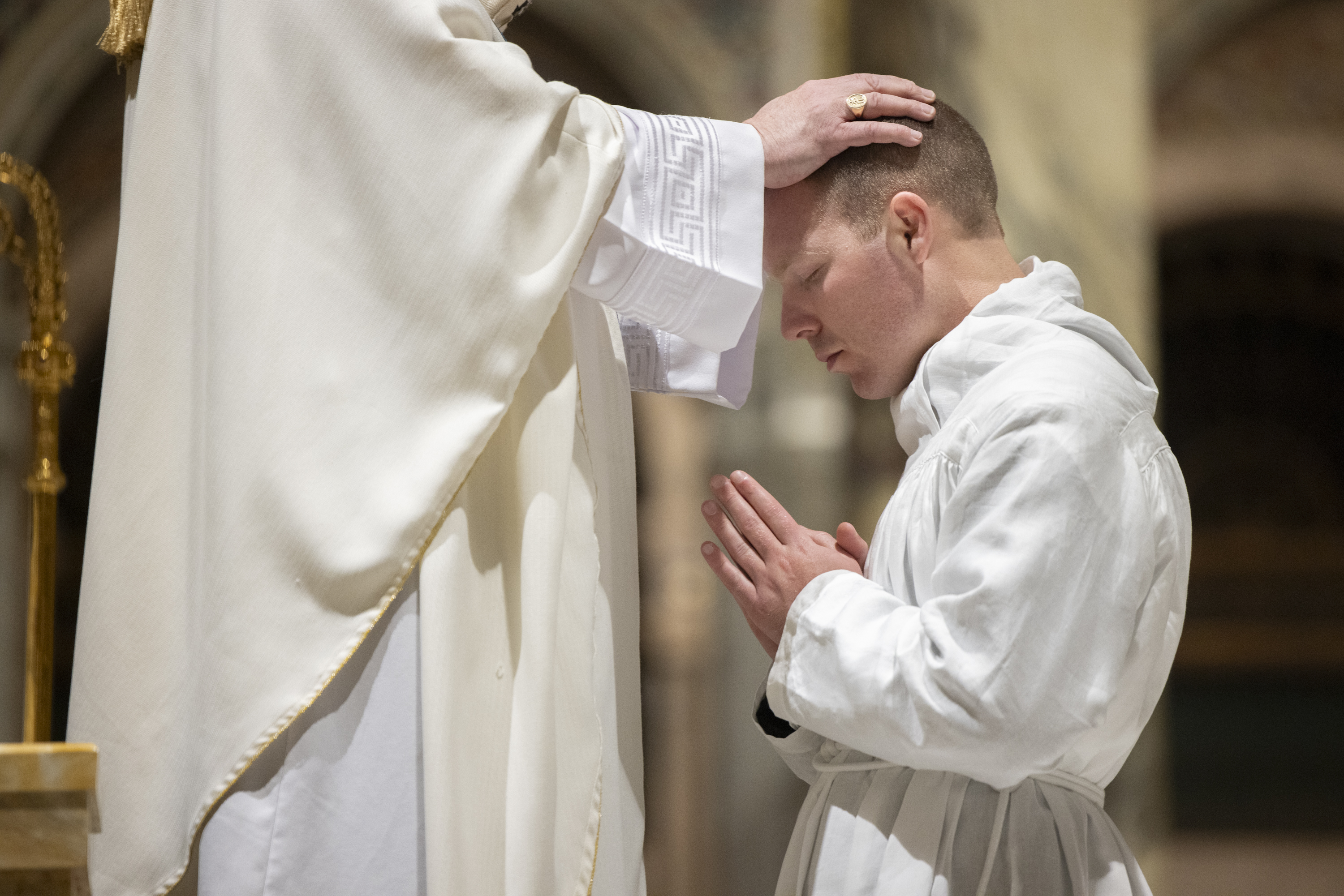 Archbishop Mitchell T. Rozanski placed his hands on the head of Alex Cammarata during the rite of ordination of deacons.